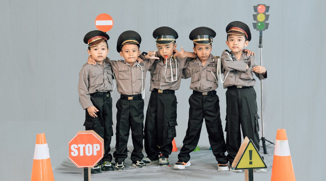 Berpose di antara rambu STOP dan kerucut lalu lintas
